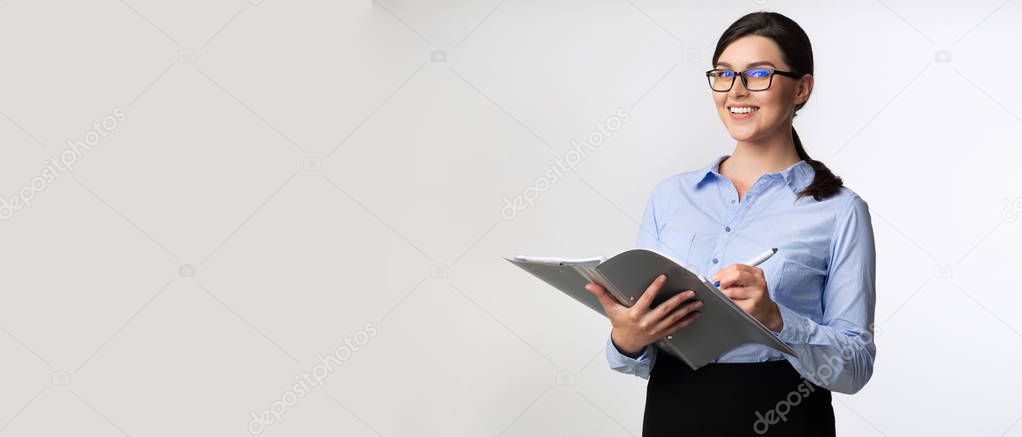 Businesswoman Taking Notes Holding Folder Looking At Camera, Panorama