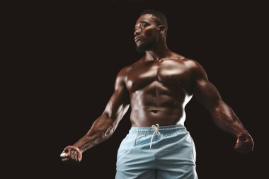 Siyah arka plan üzerinde Kas afrikalı amerikalı genç sporcu