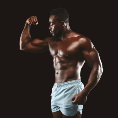 Kol kaslarını gösteren atletik Afrikalı adam