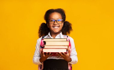 Schoolgirl Holding Kitap Yığını Kamera, Studio Shot At Gülümseyen