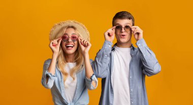 Genç çift trendy güneş gözlüğü çalışıyor, tatil için hazırlanıyor