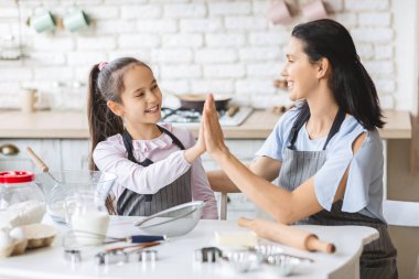 Anne ve kızı mutfakta her birine yüksek beş veren