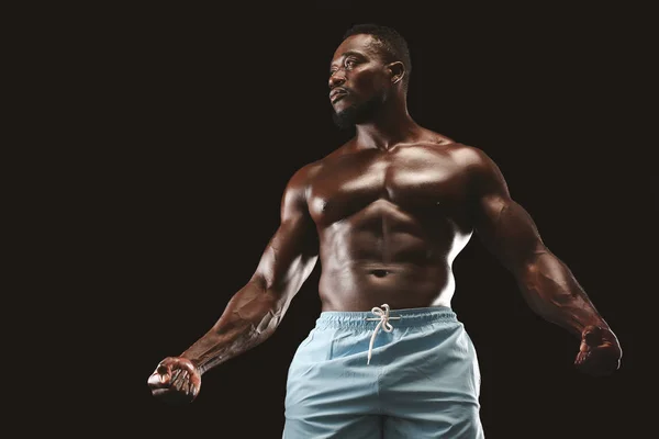 Muscular Africano americano jovem desportista sobre fundo preto — Fotografia de Stock