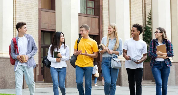 多种族学生在休息时走在大学大楼上 — 图库照片