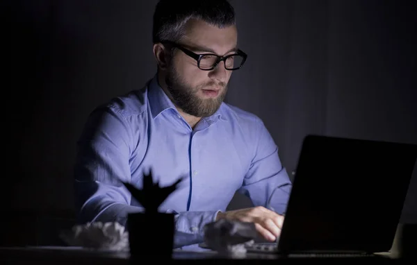 Homem focado está trabalhando até tarde, usando laptop — Fotografia de Stock