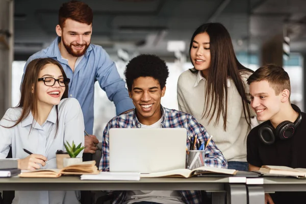 Estudiantes universitarios haciendo proyecto grupal en biblioteca — Foto de Stock