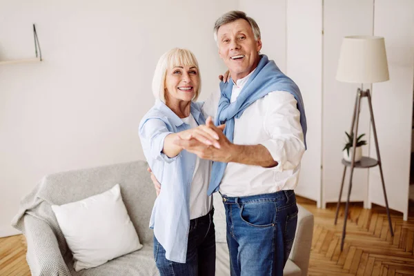 Elderly couple dancing together in the living room — Stock Photo, Image