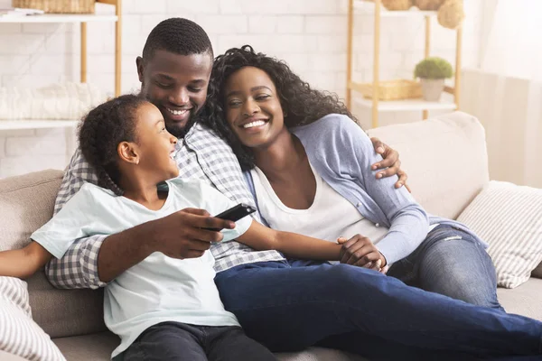 Gelukkig Afro-Amerikaanse familie ontspannen en tv kijken thuis — Stockfoto