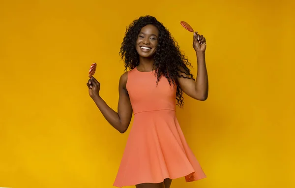 Super happy black woman holding candies in both hands — Stock Photo, Image