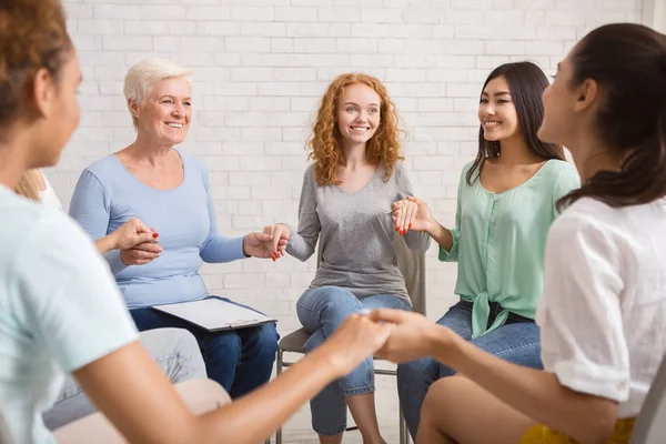 Sorrindo Diversas mulheres sentadas em círculo durante a terapia de grupo Indoor — Fotografia de Stock