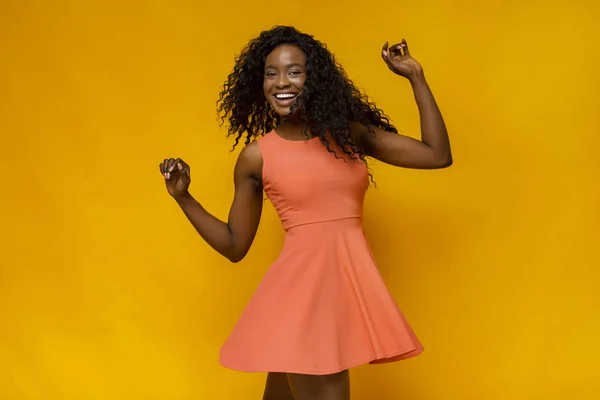 Muito jovem mulher africana dançando sobre fundo amarelo — Fotografia de Stock