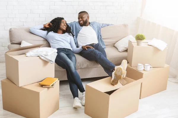 Casal no sofá fazendo uma pausa da desembalagem no dia em movimento — Fotografia de Stock