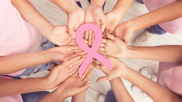 Kobieta ręce koło gospodarstwa Big Pink Ribbon stojących razem, Panorama — Zdjęcie stockowe