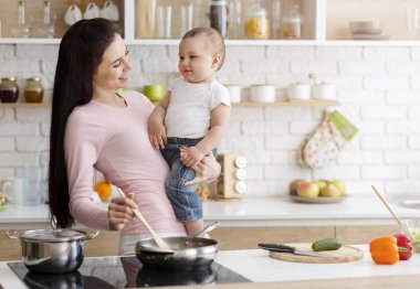 Anne mutfakta bebek ile öğle yemeği pişirme