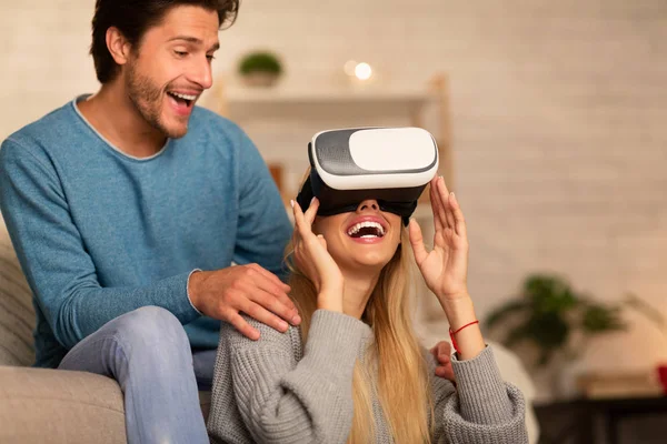 Casal usando óculos de realidade virtual jogando videogame em casa — Fotografia de Stock