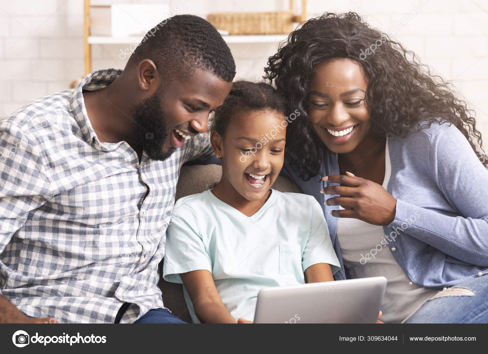 Black family watching funny videos on digital tablet at home Stock Photo by  ©Milkos 309634044