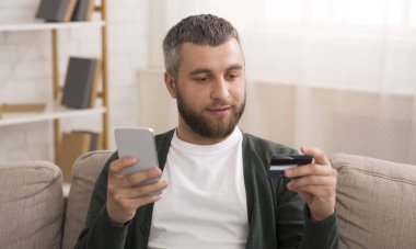 Adam kredi kartı tutan, cep telefonu ile online alışveriş yapma