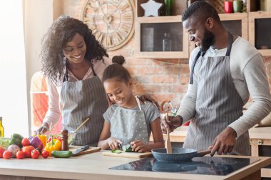 Kız ilk yemeğini yapıyor, ebeveynleri ile birlikte vakit geçiriyor