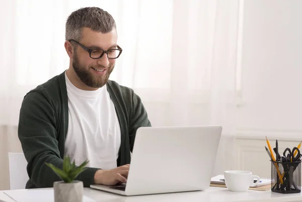 Medelålders man njuter av sitt jobb, arbetar hemifrån — Stockfoto