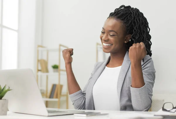 オフィスのラップトップに座ってビジネスの成功を祝う黒人女性 — ストック写真