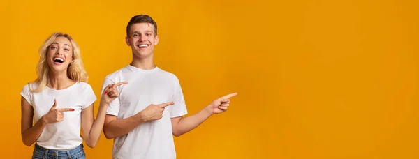 Cheerful millennial couple pointing aside at copy space — Stock Photo, Image