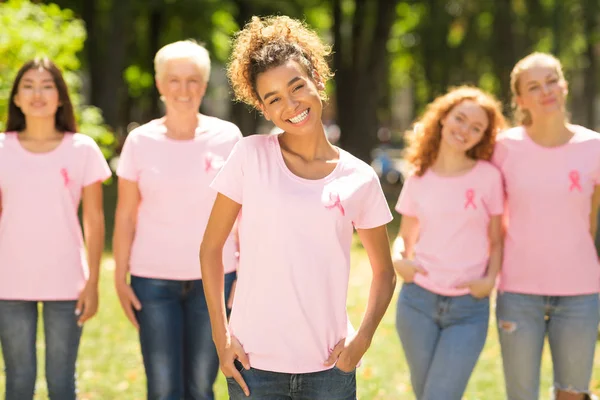 Voluntario de cáncer de mama de pie frente a diversas damas en el parque — Foto de Stock