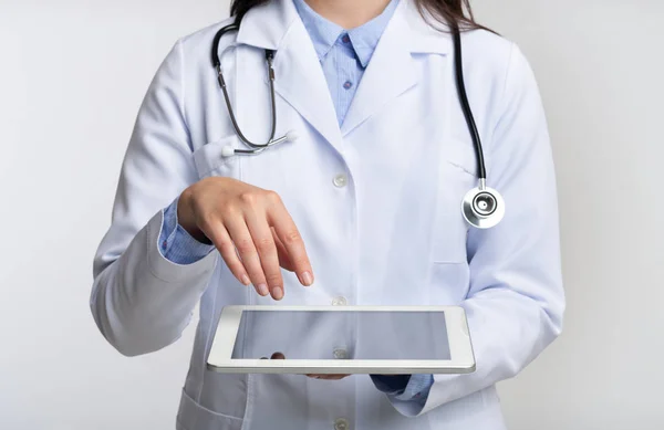 Médico irreconocible usando Tablet Computer, fondo blanco, recortado —  Fotos de Stock
