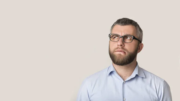 Confused businessman looking at copy space, biting lips — Stock Photo, Image