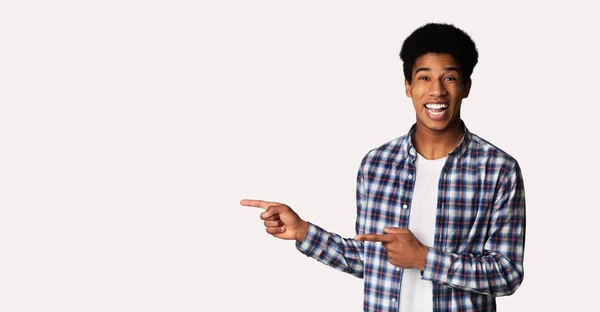 Feliz chico afroamericano apuntando al espacio libre — Foto de Stock