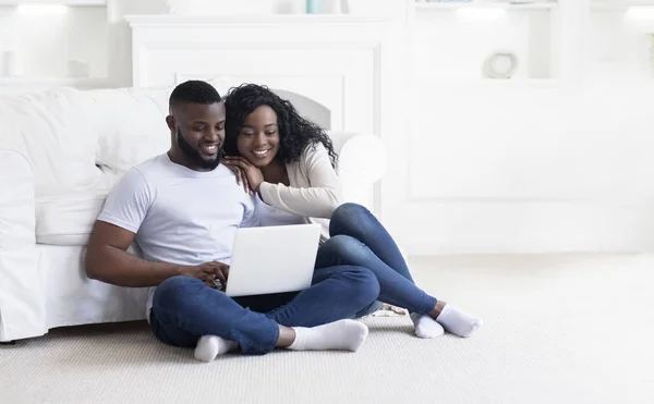 Joven pareja negra usando laptop en casa planeando vacaciones de verano —  Fotos de Stock