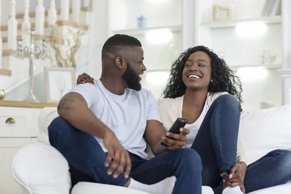 Pareja alegre sentada en el sofá viendo videos divertidos en la televisión —  Fotos de Stock