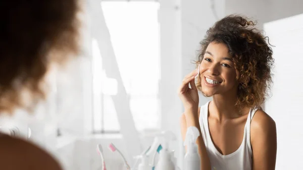 Afro Girl takarítás Face használata Cotton alátét a fürdőszobában, panoráma — Stock Fotó
