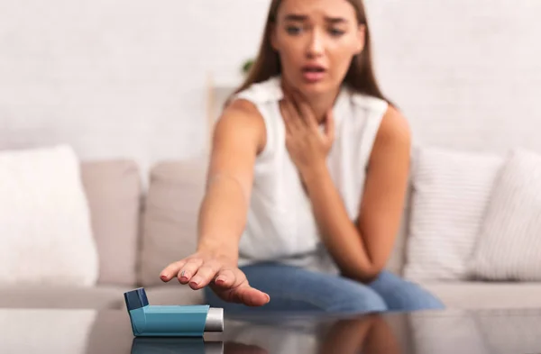 Niña alcanzando el inhalador de asma previniendo la depresión respiratoria en casa — Foto de Stock