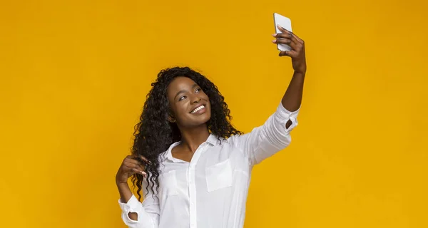 Coqueteando chica africana haciendo selfie en su teléfono inteligente — Foto de Stock