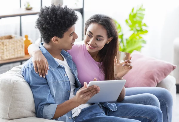 Casal jovem usando tablet e cartão de crédito em casa — Fotografia de Stock