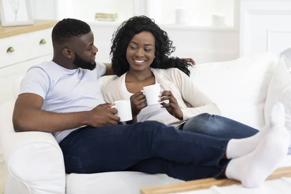 Pareja afroamericana relajándose en casa con una taza de café — Foto de Stock