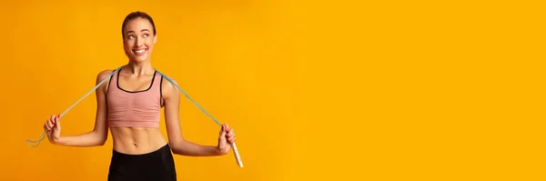 Lächelnde Frau mit Springseil posiert im Studio, Panorama — Stockfoto