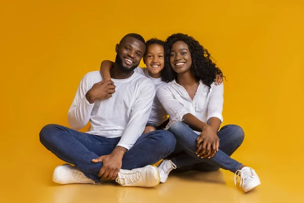Feliz família afro-americana de três sobre fundo amarelo — Fotografia de Stock