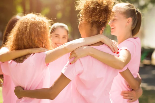 Olika flickor i bröst cancer T-shirts omfattar stående i parken — Stockfoto
