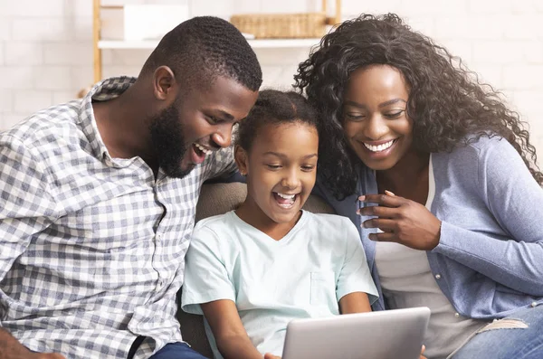 Família negra assistindo vídeos engraçados em tablet digital em casa — Fotografia de Stock