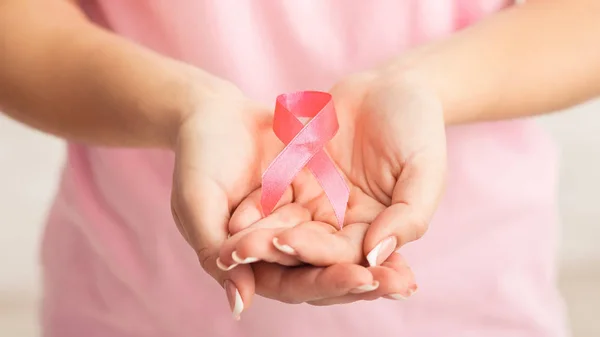 Donna irriconoscibile che mostra nastro rosa del cancro al seno, sfondo bianco, Panorama — Foto Stock