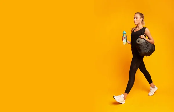 Mujer yendo al gimnasio llevando una bolsa de fitness, estudio —  Fotos de Stock