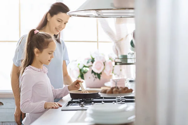 Το κοριτσάκι μαθαίνει πώς να μαγειρεύει υπό την επίβλεψη της μητέρας. — Φωτογραφία Αρχείου