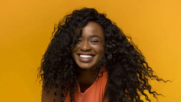 Portret van Happy Black krullend vrouw op gele achtergrond — Stockfoto
