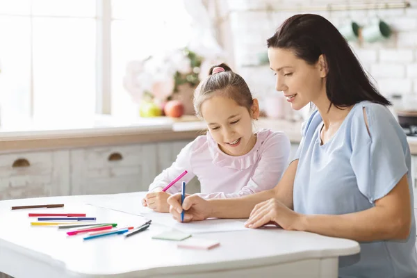 Мать и дочь рисуют цветными маркерами вместе — стоковое фото