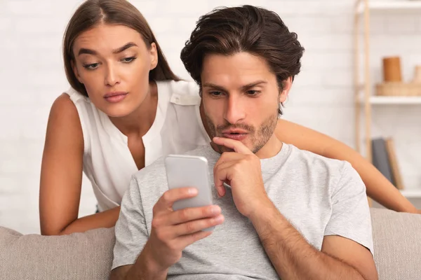 Girlfriend Spying On Boyfriend While He Chatting On Cellphone Indoor — Stock Photo, Image