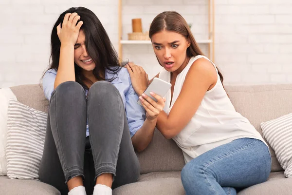 Girl Showing Friend Breakup Message Sitting On Sofa Indoor