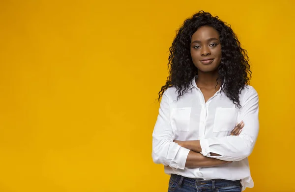 Zelfverzekerde jonge Afrikaanse vrouw poseren op gele studio achtergrond — Stockfoto
