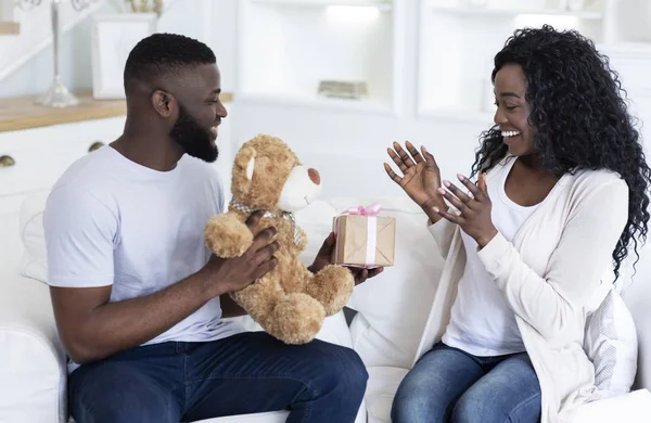 Romantic surprise. Millennial guy giving present to his pleased girlfriend — Stock Photo, Image