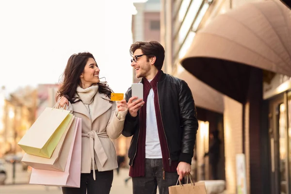 Nakupování online, dvojice se smartphone a kreditní kartou v blízkosti centra města — Stock fotografie